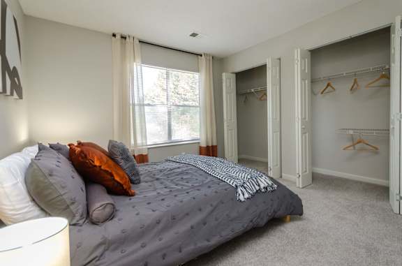 a bedroom with a bed and some closet space at The Carter 4250 Apartments, Norcross, 30093